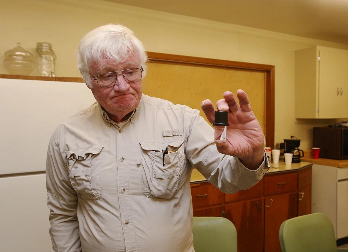 Mike Matthews holds a vial he uses when testing for nitrate in water on December 1. Each test costs $16. There are 37 reverse osmosis, or RO, systems to test in town. Prosser is one of many towns grappling with the costs of trying to remove nitrate from their water supply – roughly 10 percent of Nebraska communities have tested nitrate levels higher than the federal standard at least once since 2010. Photo by Laura Beahm for the Flatwater Free Press Mike Matthews holds a vial he uses when testing for nitrate in water on December 1. Each test costs $16. There are 37 reverse os