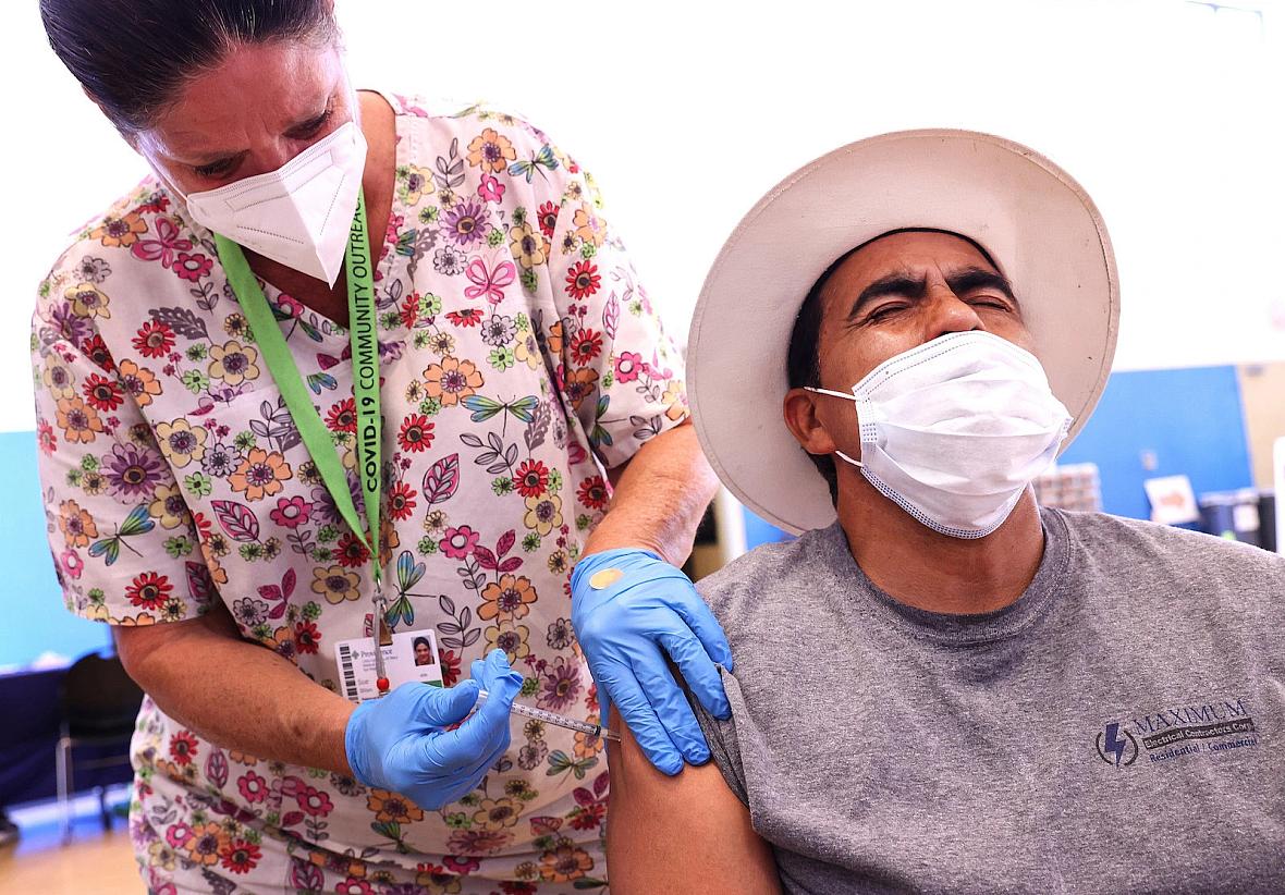 Registered nurse Sue Dillon administers a dose of the Pfizer COVID-19 vaccine to a person at a clinic in Wilmington, California.