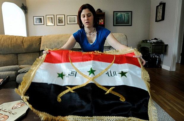 Former U.S. Army Spc. Casey Elder, a veteran of the Iraq war, shows an Iraqi flag that she bought in Baghdad. Elder, a Purple Heart recipient, suffers from post-traumatic stress disorder and traumatic brain injury. A roadside bomb struck her Humvee in Baghdad.  