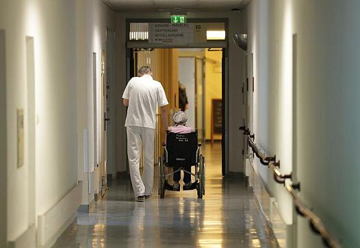 Person walking alongside someone in a wheelchair