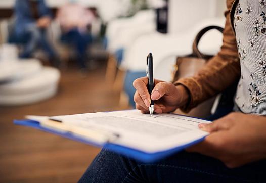 A woman fills out forms at a medical office.