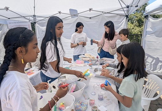 Young Desi youth volunteers work with children on an art project