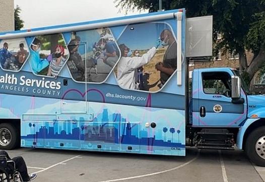 A Black man in a wheelchair waits to be seen at a mobile clinic in the Central Valley. 