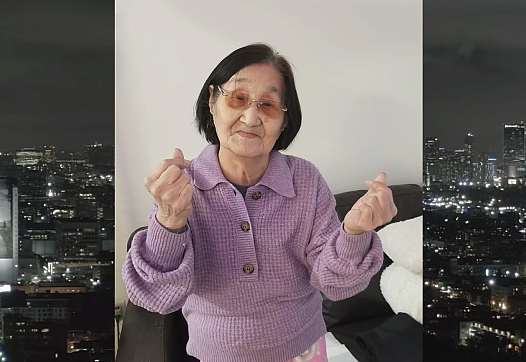 a 97-year-old Korean American woman wears a purple sweater