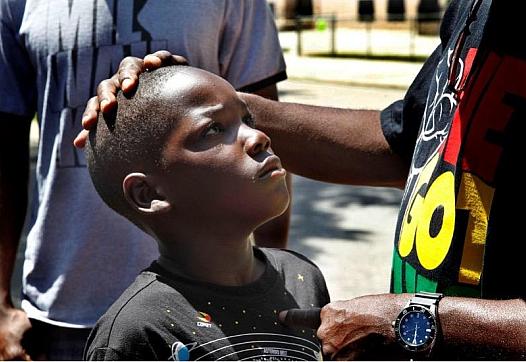 An adult consoling a child by stroking their head