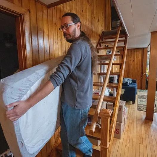 Erick Vertein shown moving a mattress.