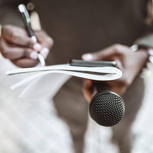 Journalist with notebook and microphone.