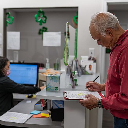 A man fills out paperwork at the doctor's office.