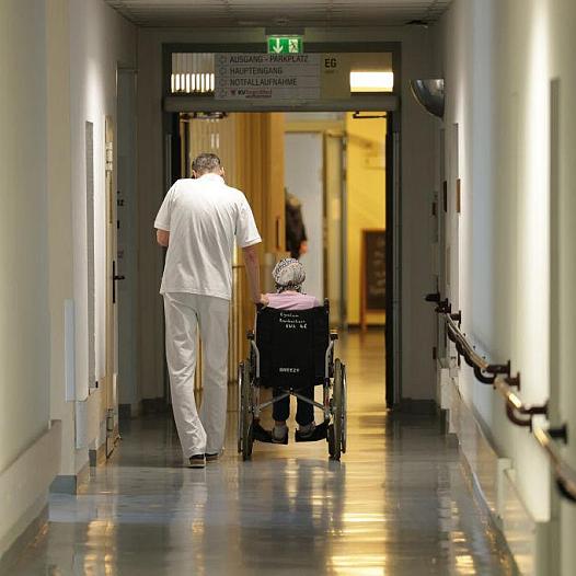 Person walking alongside someone in a wheelchair