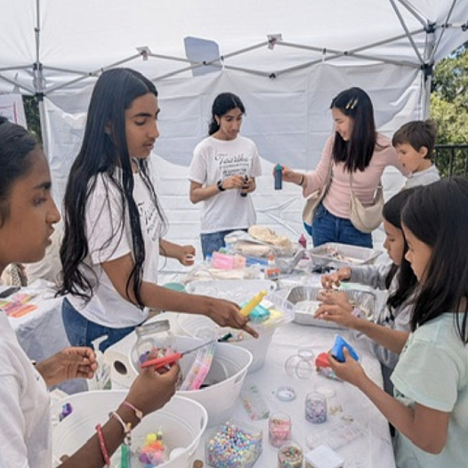 Young Desi youth volunteers work with children on an art project