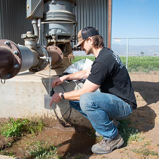 Person drawing water from a pipe