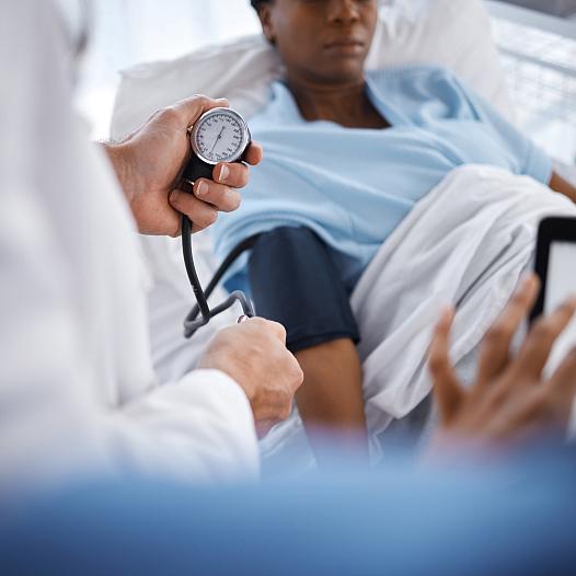 A health care provider takes the blood pressure of a patient.