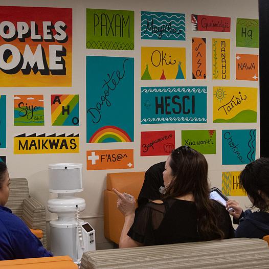 Three women wait in the colorful waiting room of UAII in Echo Park, Los Angeles