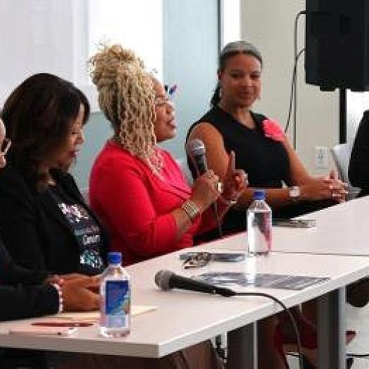 People at a table, with a person talking on a mic