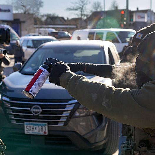 A person brandishing a spray upon journalists