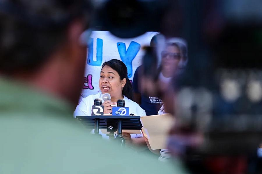 a man watching a woman speaking into a mike