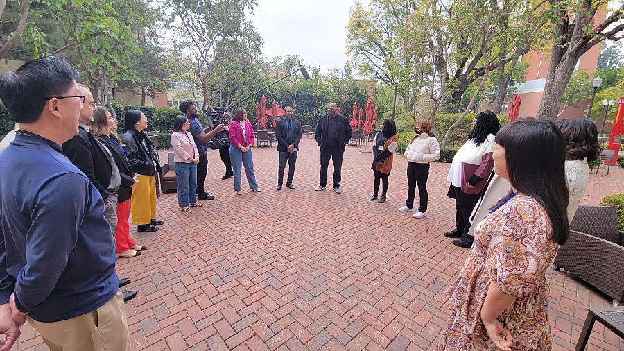 Reporters gather in a circle on the USC campus.