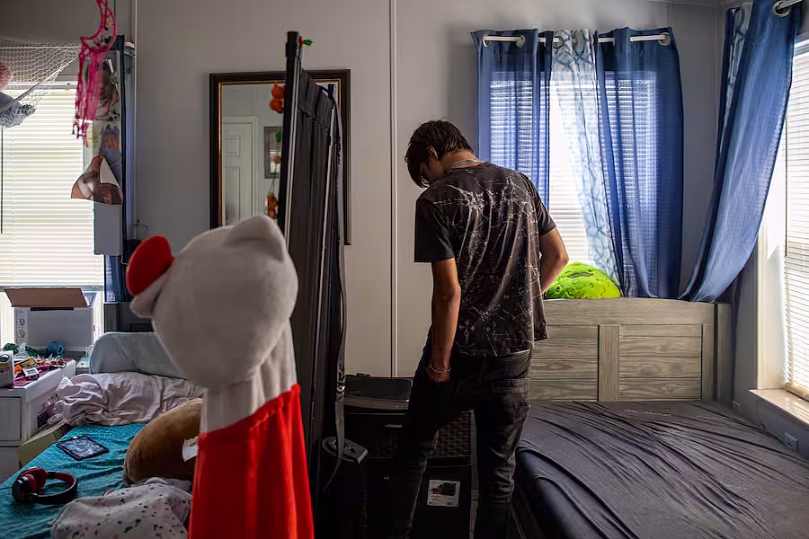 Jaden Flora walks through the small room he shared with his 11-year-old sister