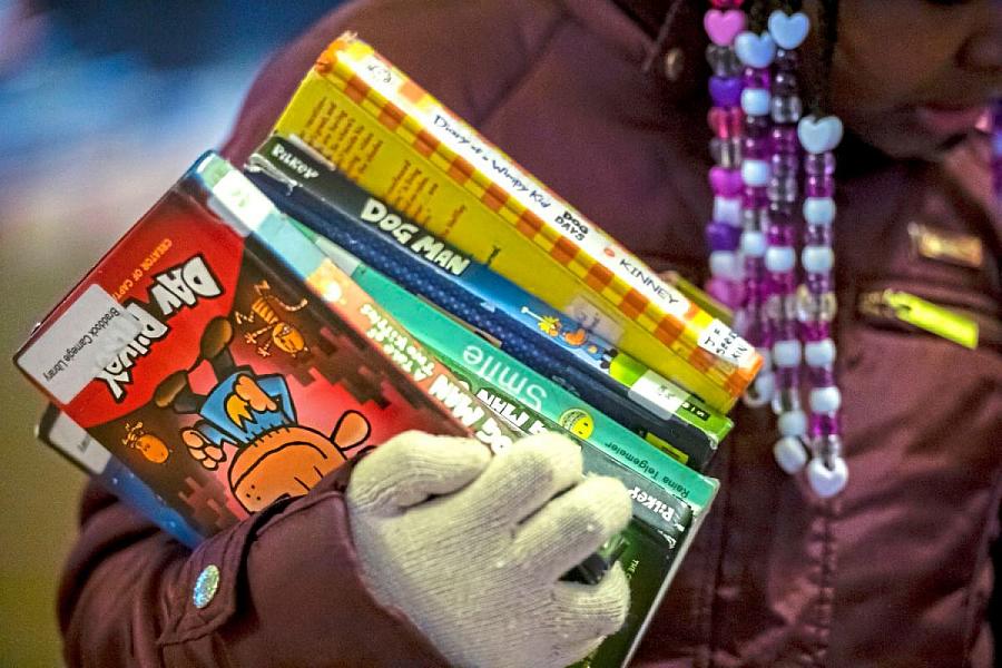 Child holding a stack of books