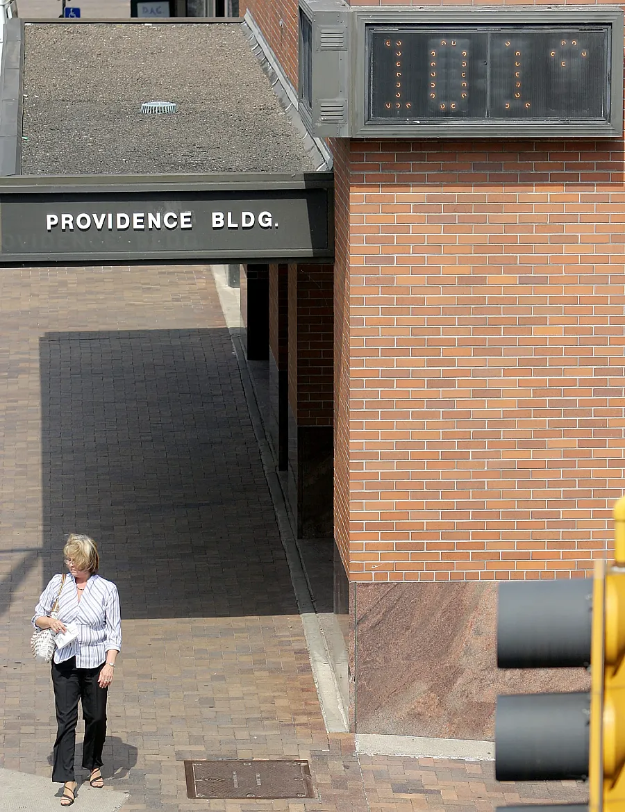 A pedestrian walks past the Providence Building thermometer reading 101 degrees on Superior Street and Fourth Avenue West on Friday, July 28, 2006.