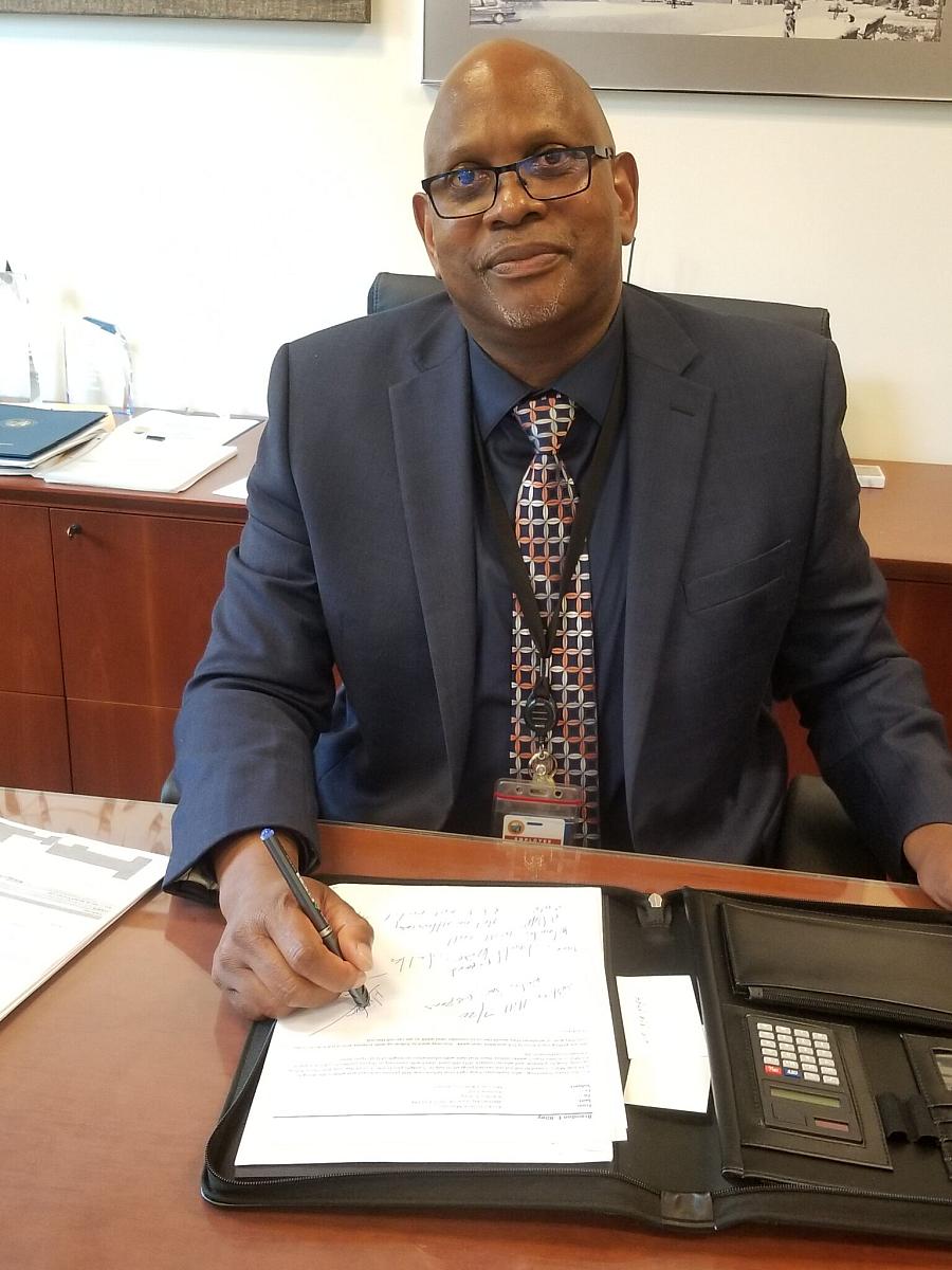 Image of a black man sitting across the desk