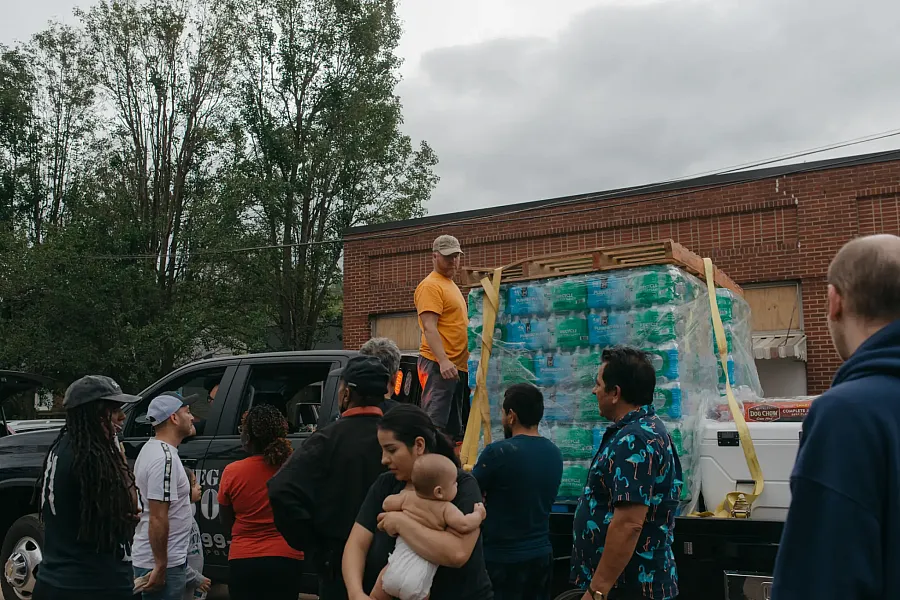 A volunteer&nbsp;distributes&nbsp;supplies to community members 
