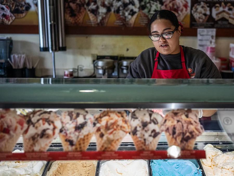 A girl working behind a a counter in a shop 