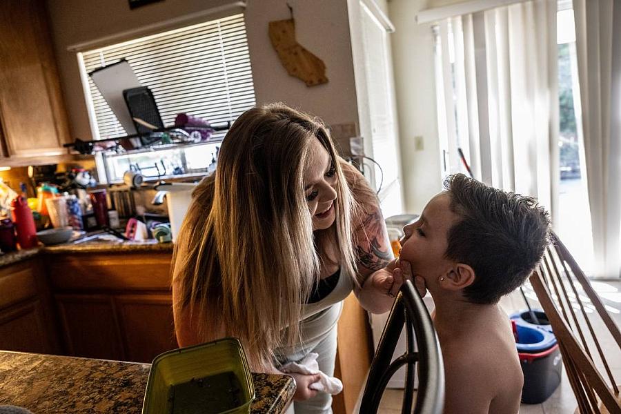 A mother inspecting her son's face