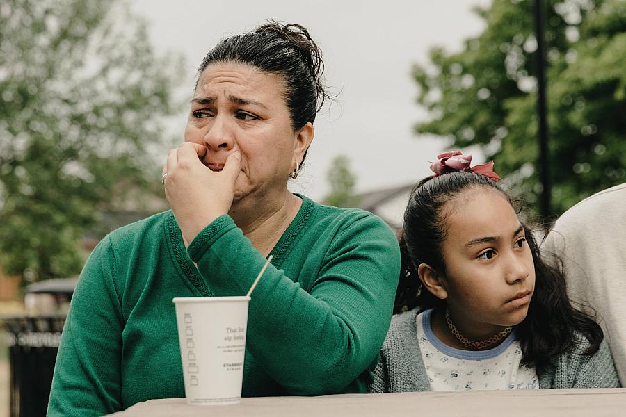 A lady tearing up while sitting next to a child