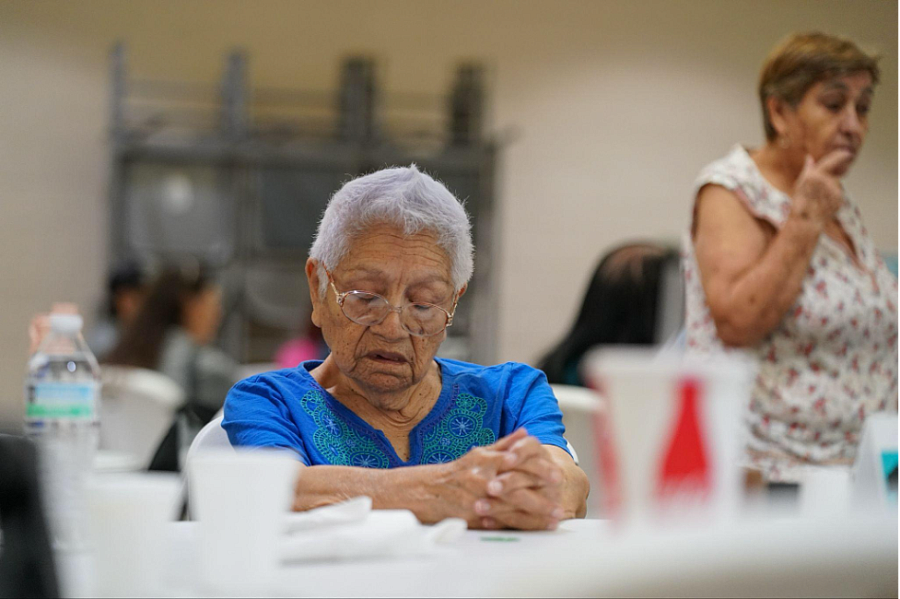 A woman praying before eating