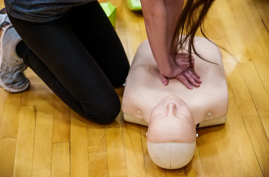 A student performing CPR on a CPR Doll