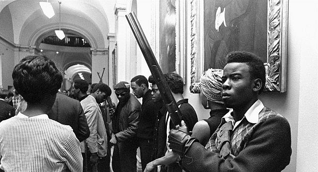 Black and white picture of a person holding a gun