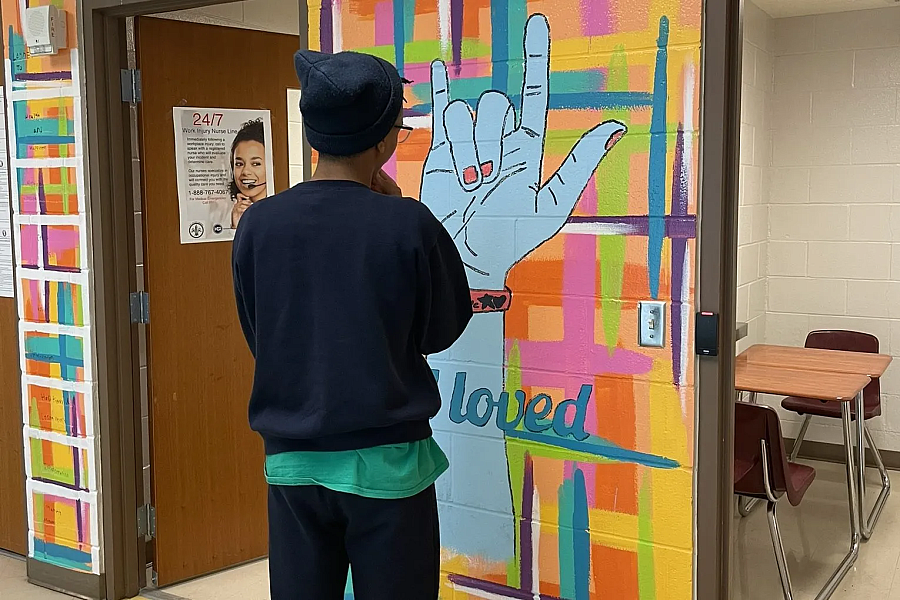 Person facing a wall mural