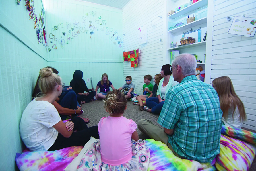 Group of people and children sitting in a circle