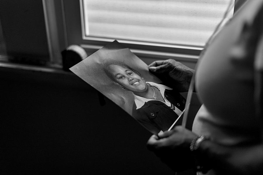 Black and white picture of hands holding a picture of a person