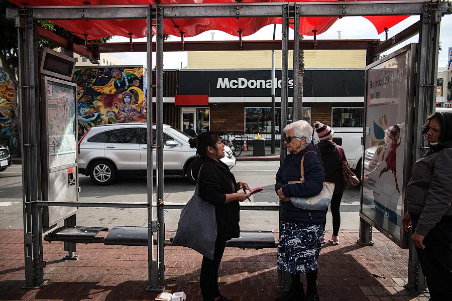 Two people at a bus stop
