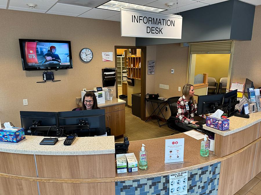 Two people behind an information desk 