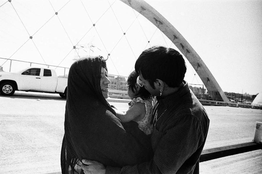 A black and white photo of the artist with his partner and child.