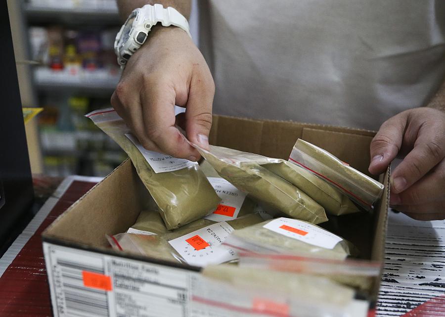 Image of person checking kratom powder plastic bags