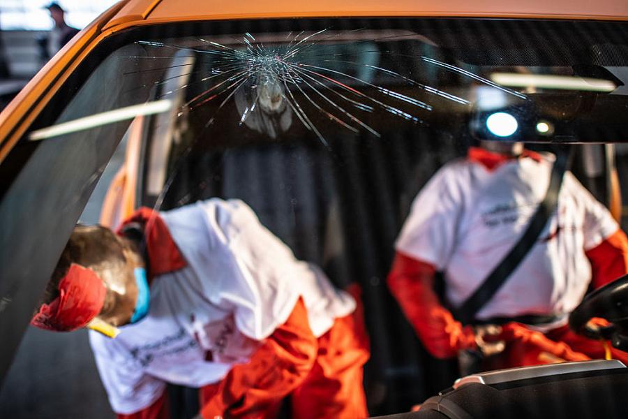 crash test dummies in a car with broken wind shield