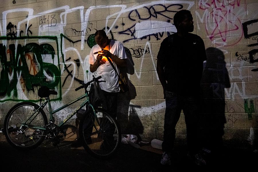 A man smokes fentanyl in an alley near MacArthur Park in Los Angeles.