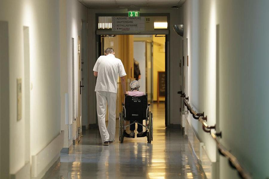 Person walking alongside someone in a wheelchair