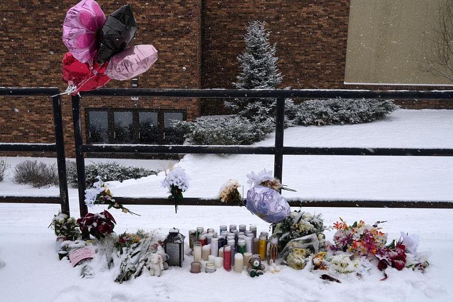 balloons and flowers by a fence in the snow