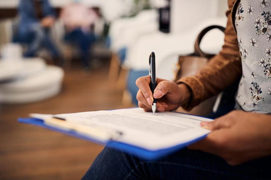 A woman fills out forms at a medical office.