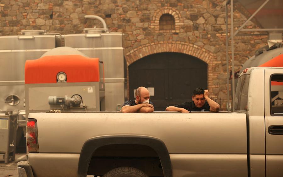 Image of two people sitting in the back of pickup truck tensed and one is wearing mask