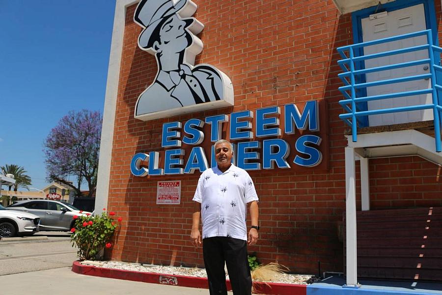 Person standing in front of cleaners sign