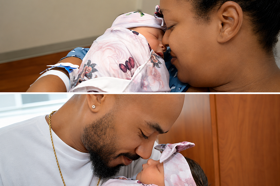 A Black couple holds their infant daughter nose to nose 