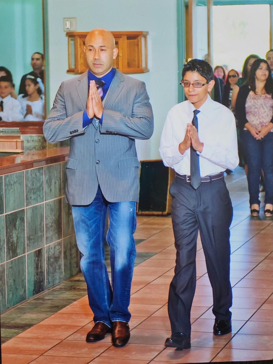 a man and an adolescent with their hands together