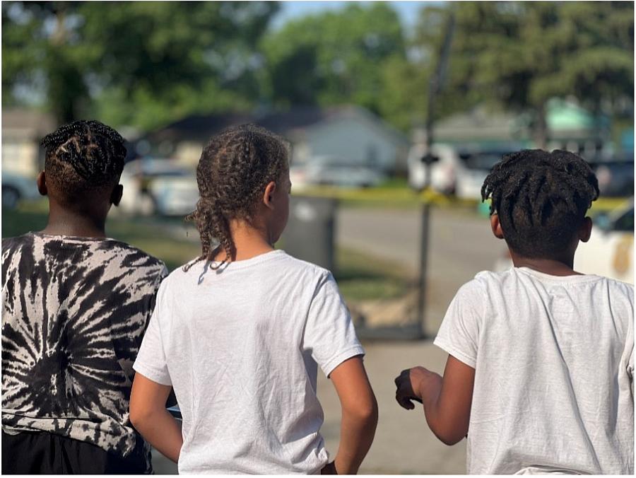 Image of three young boys in back pose on streets