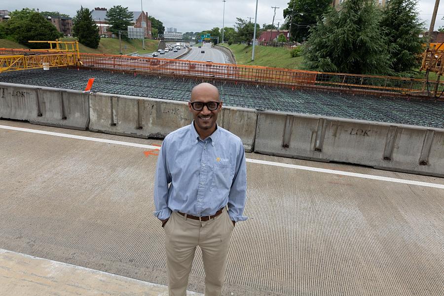 Person smiling in front of a construction site